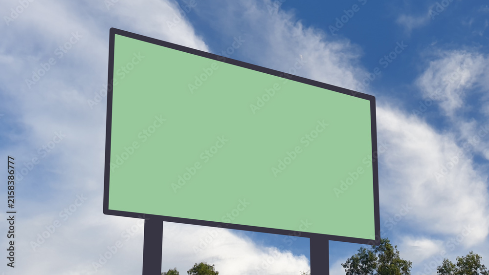 Fototapeta premium Blank billboard mockup with green screen against a blue sky with clouds, ideal for outdoor advertising, marketing, and promotional banner design.