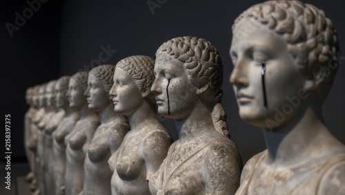 Row of Classical Statues with Tearful Expressions in a Gallery