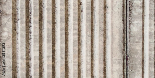 Obraz na płótnie Concrete surface with vertical grooves and a weathered texture.