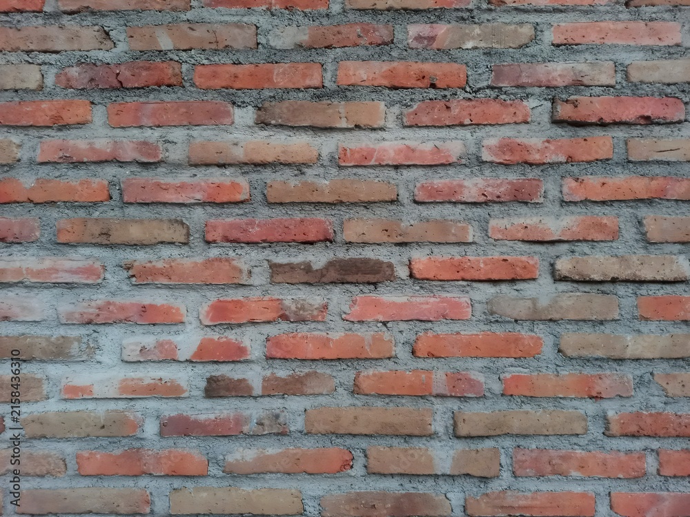 Fototapeta premium ​Rustic exposed red brick wall backdrop for architectural design, urban background, and construction graphic texture.