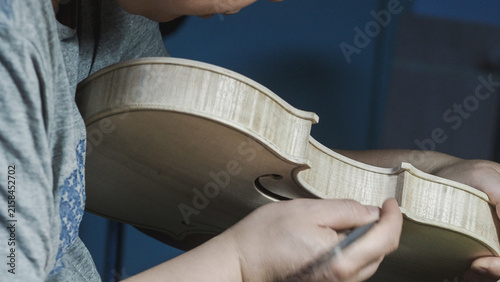 Foto Close up of a luthier's hands meticulously crafting a violin, demonstrating the