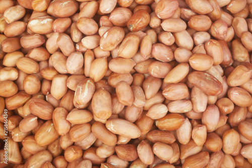 Many raw peanuts as background	