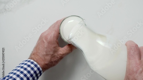 Fotografía Man's hand pours fresh milk