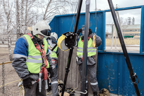 Quadro su tela Construction workers in safety gear are preparing for a lifting operation at a work site