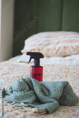 Fotografie Spray bottle on bed with a patterned blanket