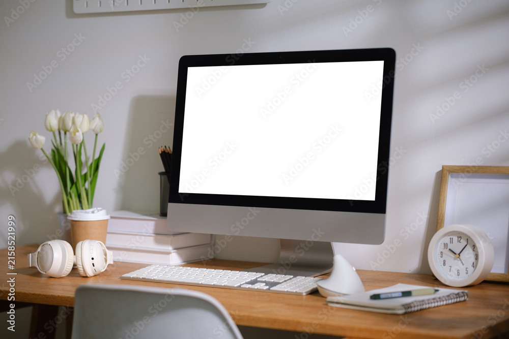 Fototapeta premium Blank desktop monitor displayed on a modern wooden desk for a digital mockup.