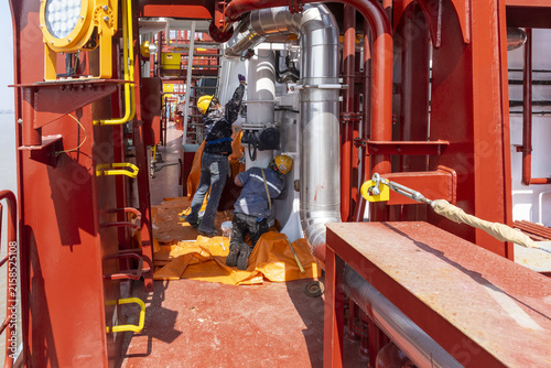 Foto Workers performing surface preparation, cleaning and painting tasks aboard a newly built vessel during final outfitting operations