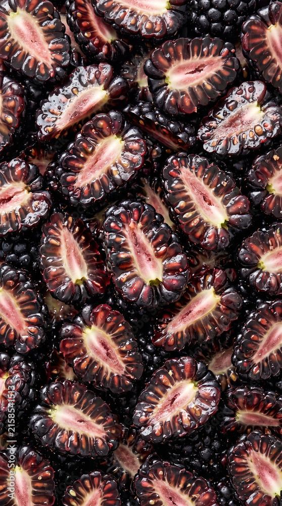 Obraz premium Close up top view of sliced fresh blackberries forming a textured background