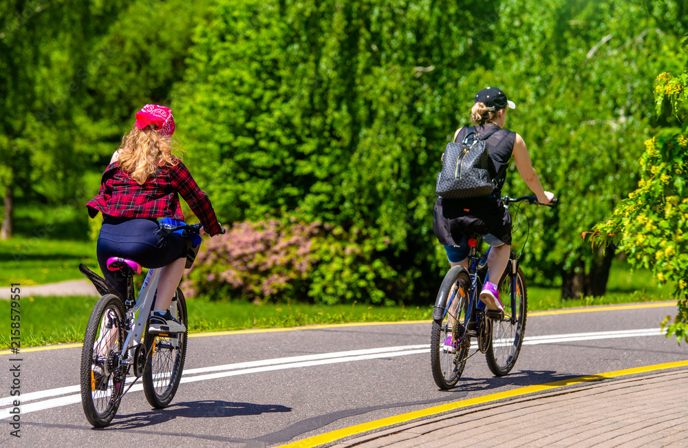 Fototapeta premium Cyclists ride on the bike path in the city Park