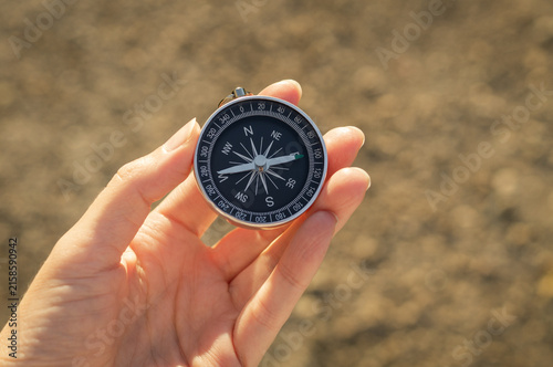 Foto Hand holding a magnetic compass outdoors, symbolizing navigation, orientation and finding the right direction
