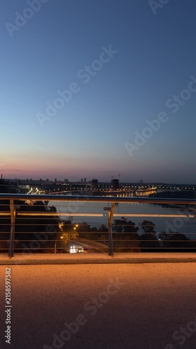 Panoramic evening view of Kyiv skyline and Dnipro River with illuminated bridges, city lights, and blue twilight sky. Urban landscape photography capturing the atmosphere of the Ukrainian capital