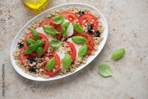 Quadro su tela Plate with italian caprese and quinoa on a beige granite background, horizontal