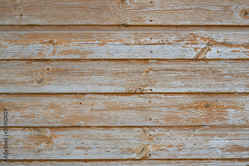 Weathered painted wood texture background with faded orange paint and exposed grey timber