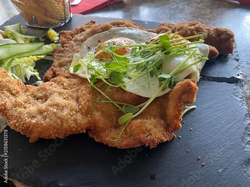 Wiener Schnitzel vom Kalb mit Spiegelei, frischem Salat und knusprigen Pommes frites. Klassisches Restaurantgericht, österreichische Küche, Hausmannskost und authentische Food-Fotografie.