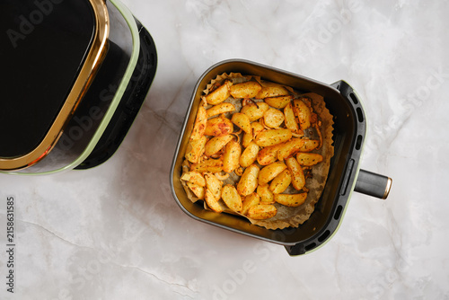 Potatoes cooked in air fryer with seasoning on kitchen countertop
