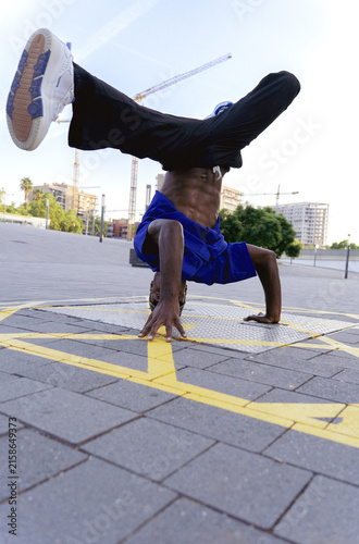 фотографія Male breakdancer balancing on his head and hands, practicing street dance acroba