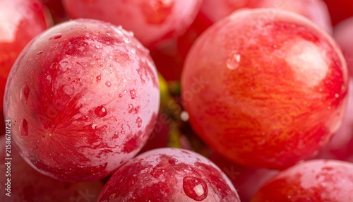 Close-up of ripe, juicy red grapes with water droplets, highlighting their vibrant color and fresh texture