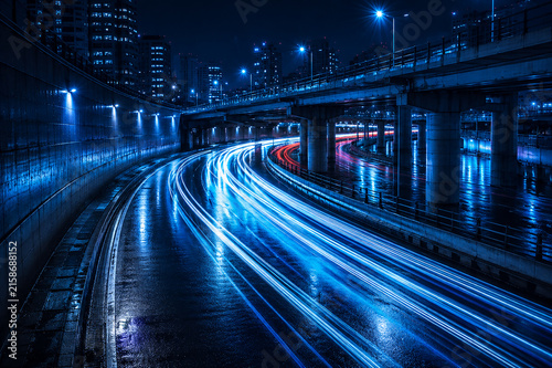 фотографія Long exposure photograph capturing golden car light trails on a curved highway