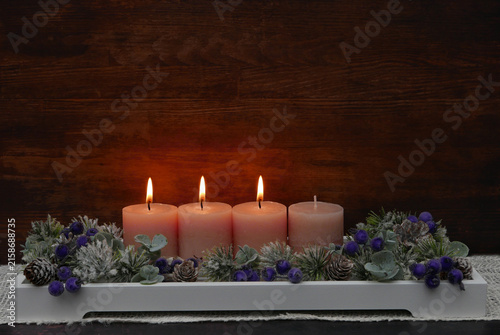 Dritter Advent: Dekoratives Adventsgesteck mit rosa Kerzen, Eukalyptuszweigen und Beeren.