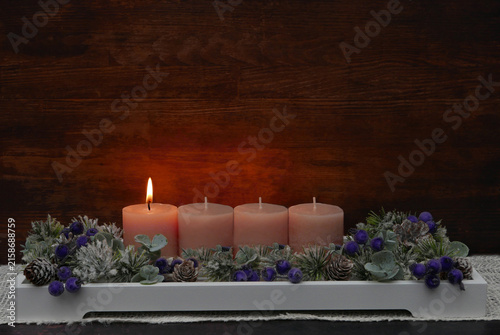Erster Advent: Dekoratives Adventsgesteck mit rosa Kerzen, Eukalyptuszweigen und Beeren.