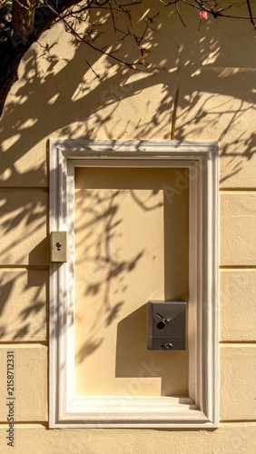 Rectangular shadow play on pale wall with framed inset and hardware