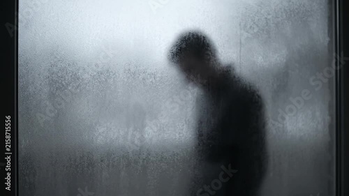 Sad Man Silhouette Behind Steamy Glass Window Looking Downward