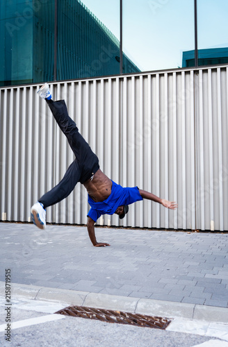 Foto African American breakdancer performing a dynamic handstand power move with legs