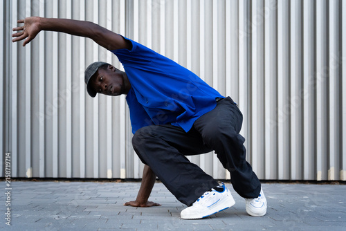 Obraz na plátne Male breakdancer performing street dance pose outdoors, showing flexibility and