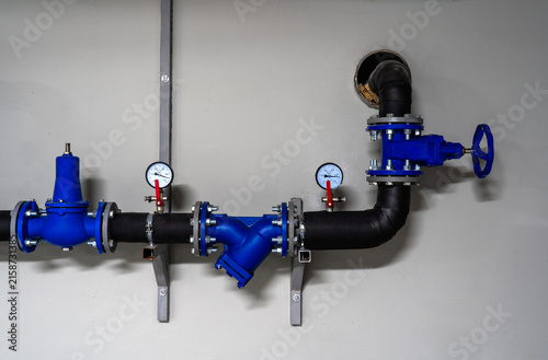 Fotografía Modern building water supply system with blue industrial valves, pressure gauges
