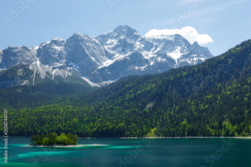 Travel landscape of Zugspitze Alps in Bavaria, Germany, scenic summer nature panorama with forest, Eibsee lake, snow mountains peak. Alpine landscape