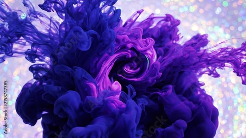 Abstract blue and purple ink clouds swirling and mixing in water against a shimmering bokeh glitter background.