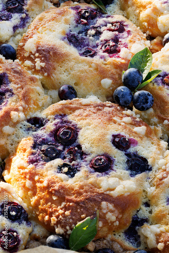 Homemade blueberry buns with addition mascarpone cheese and butter crumble topping, close-up view