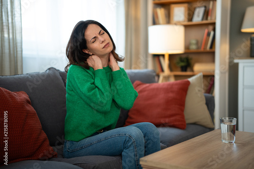 Cuadro en lienzo Woman suffering from neck pain and muscle stiffness at home