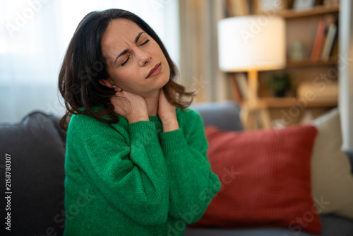 Obraz na plátně Woman experiencing severe neck pain and discomfort at home