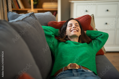 Fotografía Happy woman relaxing on sofa at home feeling leisure and comfort