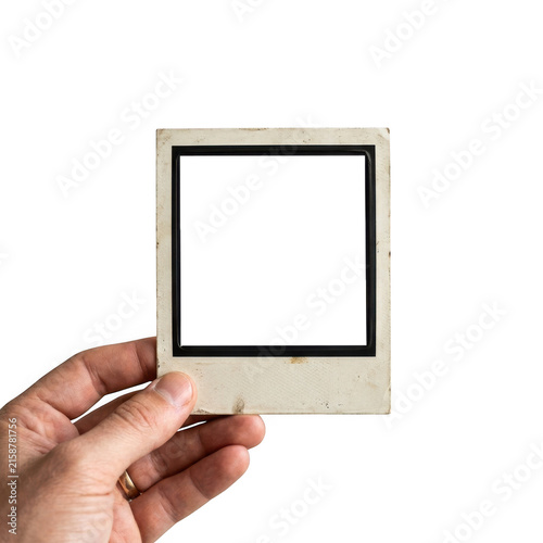 A hand holding an old vintage instant photo frame isolated on white