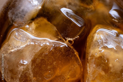 Obraz na płótnie Macro shot of crystal ice cubes float in tea or cola.