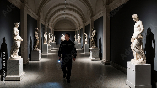 Security guard patrolling a classical museum gallery with ancient marble statues