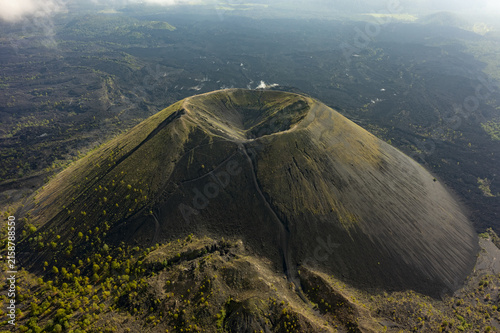 Aerial view of Paricutin volcano with volcanic cone and crater surrounded by solidified lava fields and patches of green vegetation, San Juan Parangaricutiro, Michoacan, Mexico.