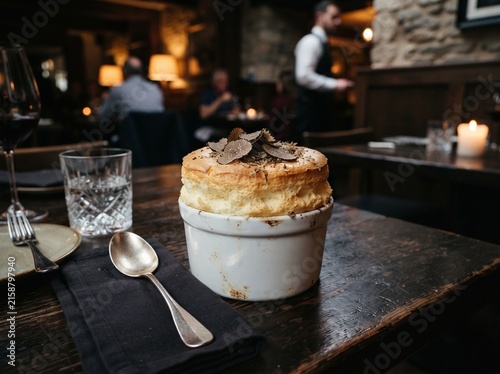 Freshly baked Black Truffle Souffle in moody fine dining restaurant.