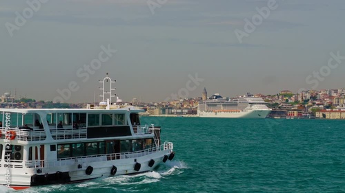 A majestic white cruise liner navigating the turquoise waters of the Bosphorus strait against the historic urban landscape and architecture of Istanbul