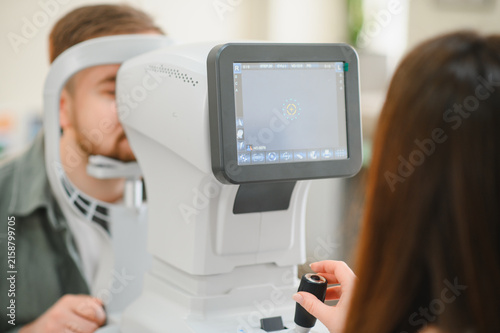 Fotografie Patient receiving eye exam using modern optical equipment
