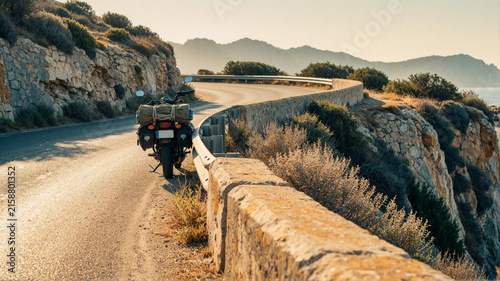 Motorcycle parked on coastal road with luggage