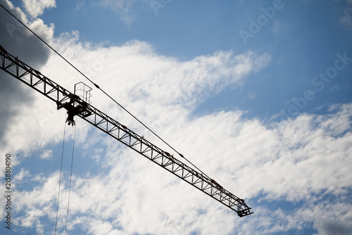 Tower crane at construction site used for lifting materials during building development, urban construction, engineering projects and infrastructure growth