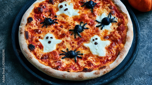 Halloween pizza with ghost and spider decoration creates playful festive meal scene