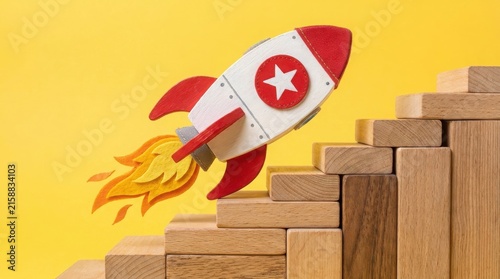 Toy rocket flying up a staircase made of wooden blocks