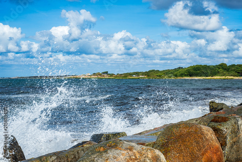 Gischt von anbrandenden Wellen spritzt über die Steinkrone der Mole von Torekov, Schonen, Schweden.