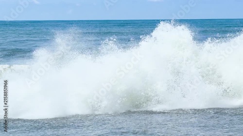 Blue sea and large waves and foam. Wave splashing over pebbles at sea. Rolling ocean waves. Summer beach background. Powerful sea waves	
