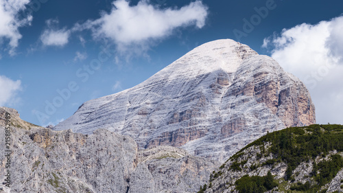 Aerial view of Tofana di Rozes mountain peak with rocky slopes and blue sky in Cortina d'Ampezzo, Veneto, Italy.