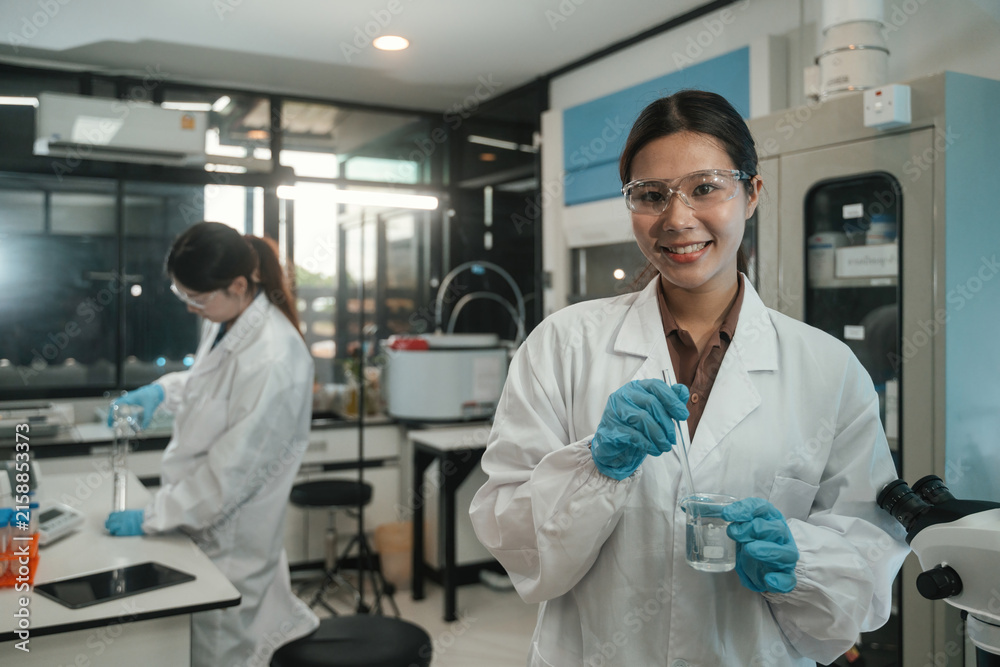 Fototapeta premium Asian Female Scientists Conducting Research Experiment with Components in Modern Laboratory